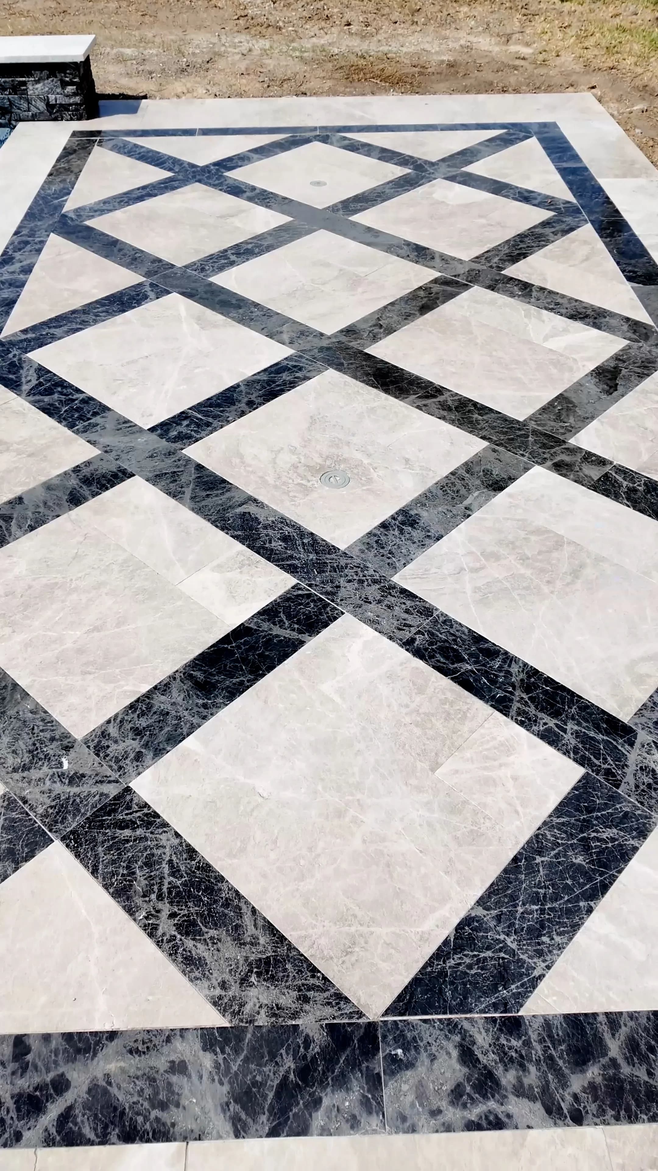 Detail of the deck's cream marble field crossed with dark polished-stone bands